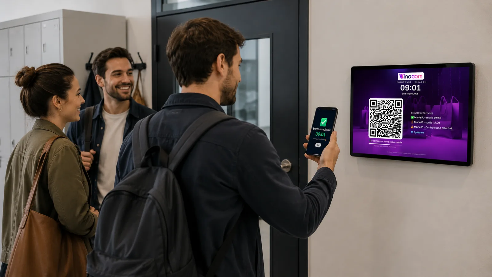 Équipe d’un commerce arrivant au travail, écran de pointage Winacom à l’entrée