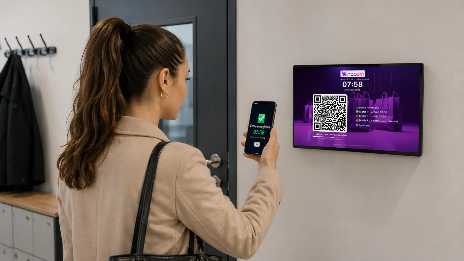 Salarié pointant son arrivée en scannant le QR code de l’écran Winacom avec le badge mobile sur son smartphone